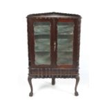 A dark wood early-mid 20th century mirror back colonial-style corner display cabinet.