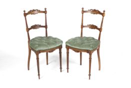 A pair of circa 1900 French button back fruitwood over stuffed boudoir chairs.
