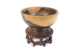 A late 20th century Chinese turned rosewood fruit bowl on carved and fretted circular stand. 23.