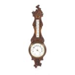 A late Victorian carved oak two glass wall aneroid barometer with porcelain dial backs.