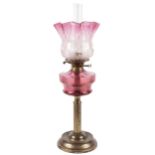 A 19th century cranberry and brass oil lamp.