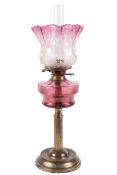 A 19th century cranberry and brass oil lamp.