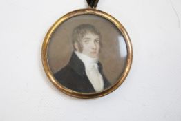 A circular Georgian portrait miniature on ivory of a Georgian gentleman wearing a stock.