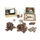 A metal box of of coins with silver 3 pences and 20th century farthings, further coins and badges.