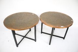 A pair of circular copper top side tables.