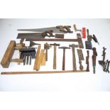 An assortment of vintage tools. Including saws, a ruler, clamps, a pen knife, etc.
