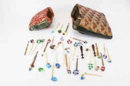 A collection of assorted lace-making bobbins and sewing accessories.