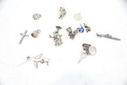 Fifteen silver charms. Including an aeroplane; a fish; a cricketer and a gun, 29.