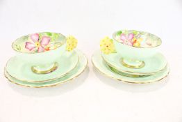 A pair of Paragon flower handle tea cup trio.