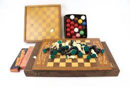 A collection of various chess sets, dominoes and snooker balls.