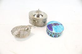 Three silver or white metal pill boxes.