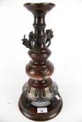 An early 20th century Japanese bronze candlestick with champleve enamel lotus decoration.