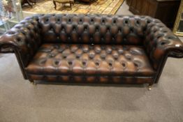 A contemporary brown leather chesterfield sofa.
