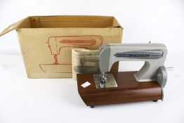 A vintage Grain toy hand crank sewing machine, boxed.