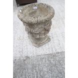 A stone garden urn with swags.