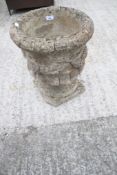 A stone garden urn with swags.