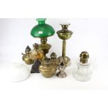 A collection of vintage brass oil lamps and accessories.