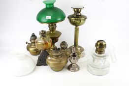 A collection of vintage brass oil lamps and accessories.