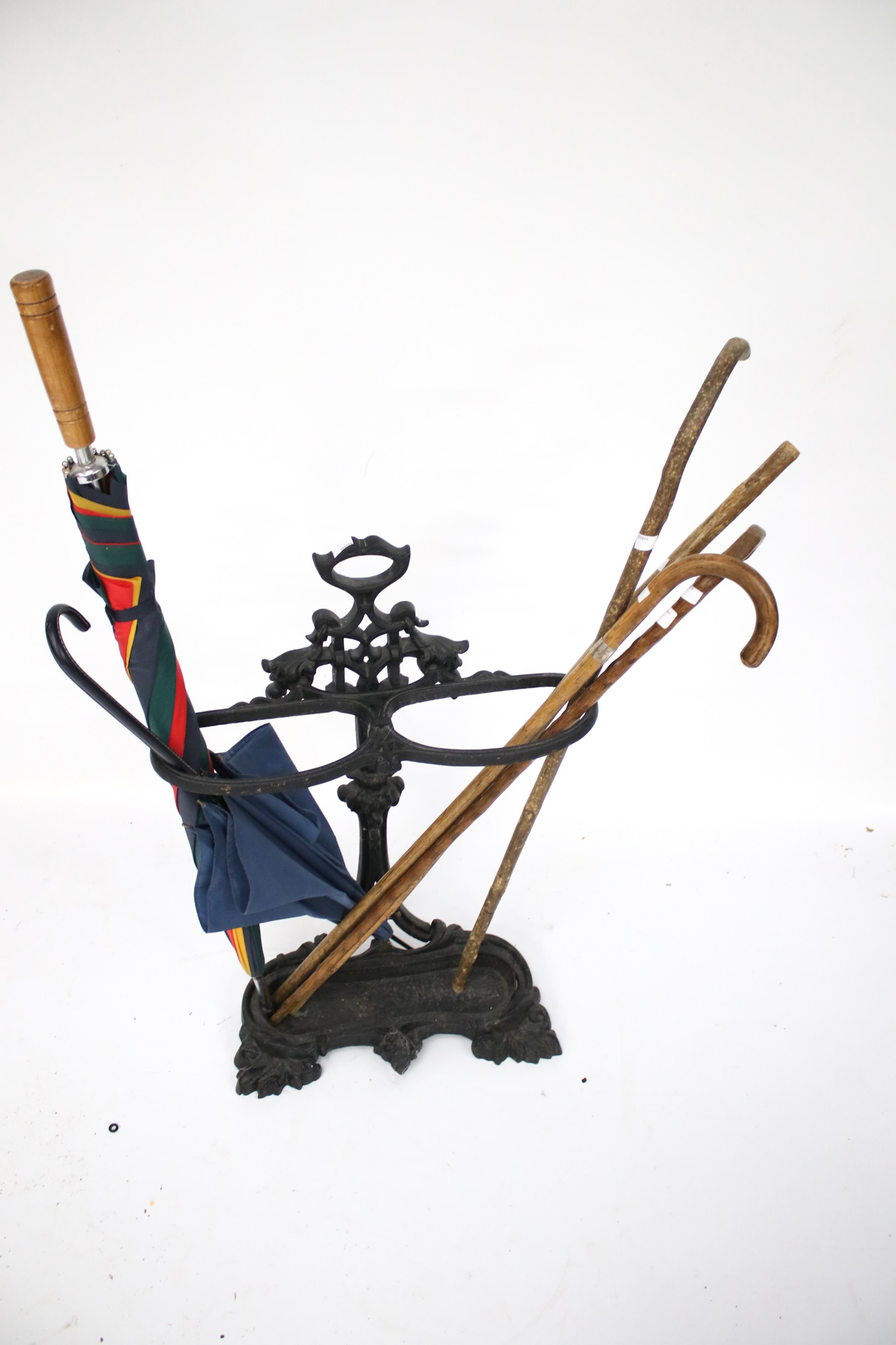 A Victorian cast metal stick and umbrella stand together with an assortment of sticks.