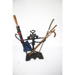 A Victorian cast metal stick and umbrella stand together with an assortment of sticks.