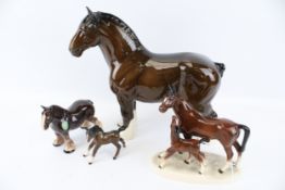 Four ceramic horse figurines. Including a Beswick Shirehorse, a Beswick pony, etc. Max.