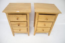 A pair of contemporary light oak bedside chest of drawers.