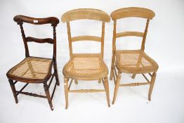 A pair of pine kitchen chairs and one other.