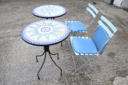 A pair of garden tables and a pair of folding chairs.