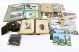 A quantity of assorted vintage postcards and glass slides.
