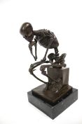 A bronze skeleton in the 'Thinker' pose, signed 'MILO'.