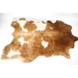 A brown and spotted cow hide rug.