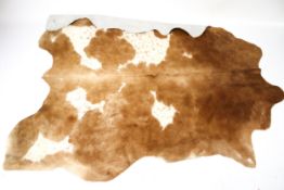 A brown and spotted cow hide rug.