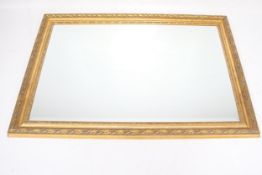 A contemporary bevelled edge gilt framed mirror.