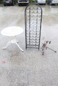 A cast metal garden table, a candelabra and a wine rack.