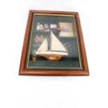 A mixed media collage of a model sail boat.