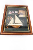 A mixed media collage of a model sail boat.