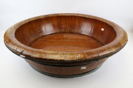 A large coopered circular wooden bowl.
