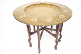 A circular brass tray top folding table.