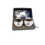 A pair of white metal napkin rings. Embossed with scenes of birds, in a fitted box, 52.