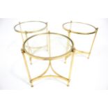 Hollywood Regency : A set of three circular brass and glass topped tables.