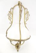 A brass pendant ceiling light with white glass shade.