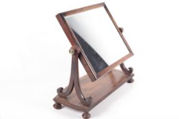 A Regency mahogany dressing table mirror with beaded bow front base.