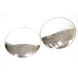 Two convex circular wall mirrors.