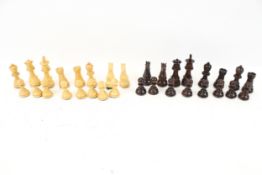 A carved wooden Staunton chess set of thirty-two pieces.