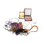 An assortment of collectables. Including strings of beads, cufflinks, a keyring, etc.