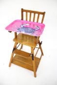 A vintage oak and plywood metamorphic child's high chair.