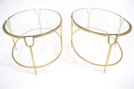 A pair of oval gilt metal framed glass topped coffee tables.