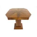 An Art Deco walnut veneer side table. Of octagonal form on a square single pedestal support.