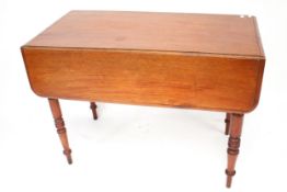 A mahogany drop leaf dining table. On turned tapering supports.