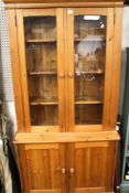 A contemporary pine part glazed display cupboard.
